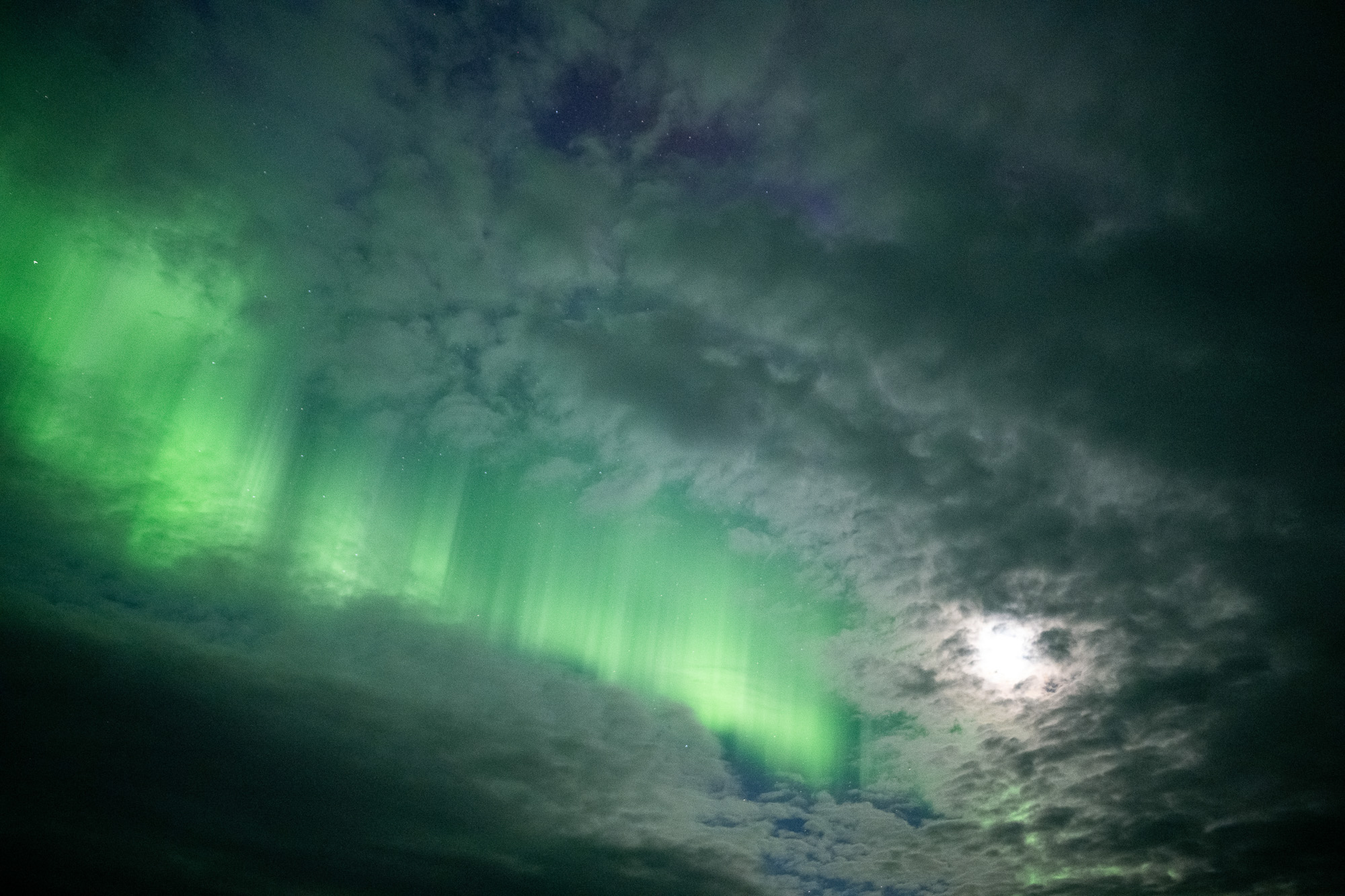 Aurora peeking through clouds in Alaska